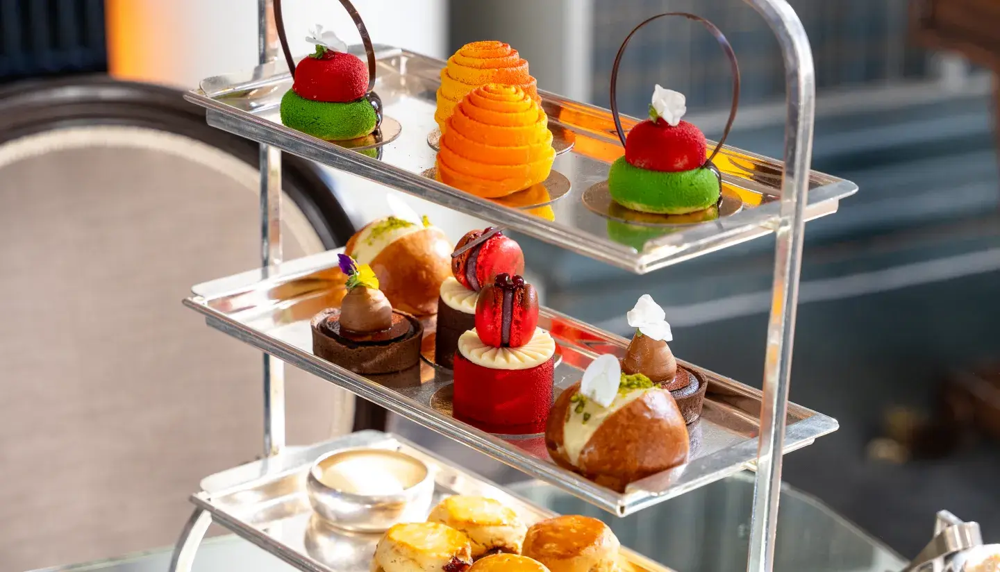 Elegantly plated dishes featuring a main course of crispy shredded pastry, topped with caviar, microgreens, and small colorful garnishes, served on light blue ceramic plates for a refined presentation.